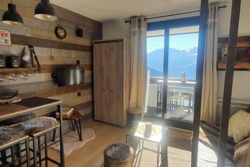 eine Küche mit einem großen Fenster mit Bergblick in der Unterkunft Studio montagnard vue splendide ALPE D HUEZ LES PASSEAUX in L'Alpe-d'Huez