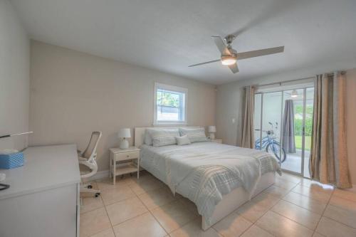 1 dormitorio con 1 cama y ventilador de techo en Bright Cottage near the Beach, en Naples
