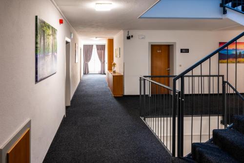 a hallway in a building with stairs and a blue light at Haiminger Hof in Haiming