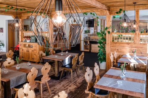 un restaurant avec des murs en bois, des tables et des chaises dans l'établissement Haiminger Hof, à Haiming