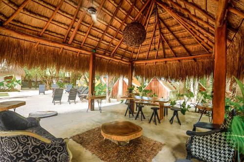 een groot paviljoen met tafels en stoelen en een tafel bij Totem Buenavista in Bacalar