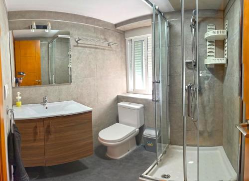 een badkamer met een douche, een toilet en een wastafel bij Apartamento Plaza Viuda in Cádiz