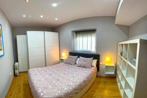 een kleine slaapkamer met een bed en een raam bij Apartamento Plaza Viuda in Cádiz