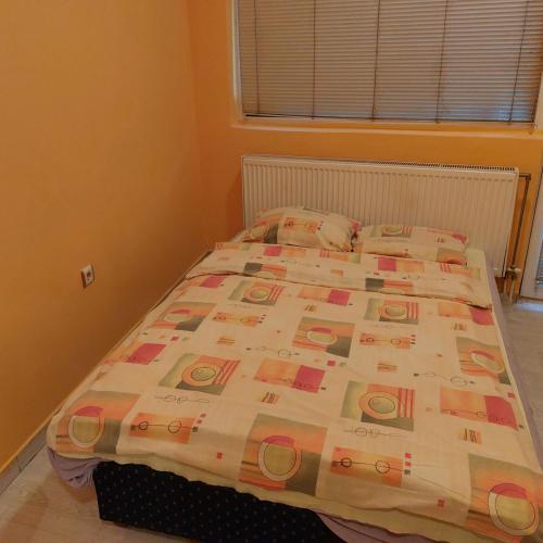 a bed with a quilt on it in a bedroom at Soba Lara in Kruševac
