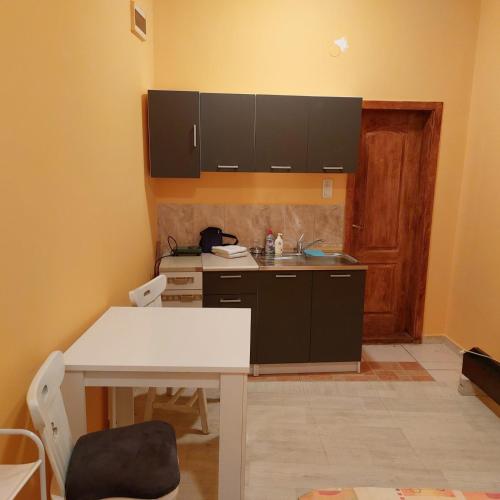 a kitchen with a white table and a sink at Soba Lara in Kruševac