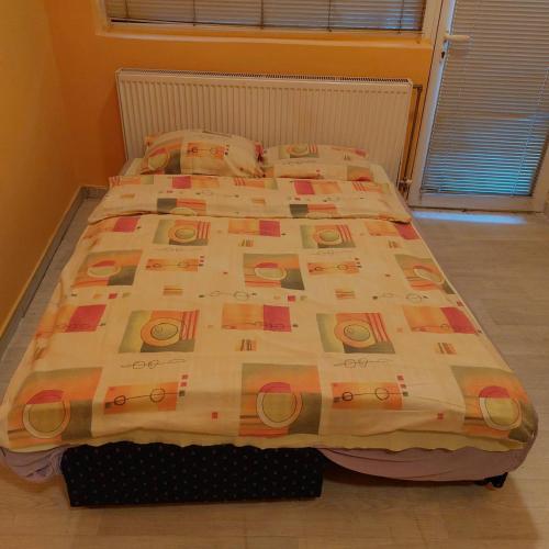 a bed with a comforter on it in a bedroom at Soba Lara in Kruševac
