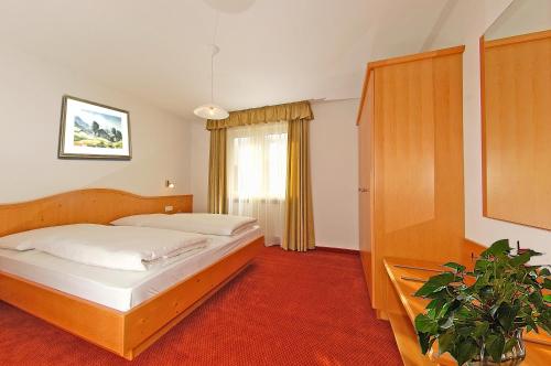 - une chambre avec deux lits et une plante en pot dans l'établissement Haus Ploner, à Castelrotto