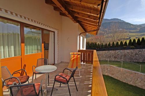 eine Terrasse mit einem Tisch und Stühlen sowie einem Balkon in der Unterkunft Haus Ploner in Kastelruth