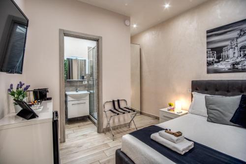 1 dormitorio con cama, escritorio y silla en Tacito 23 Luxury rooms en Roma