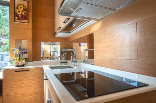 a kitchen with a sink and wooden cabinets at Three Monkeys Villas in Patong Beach
