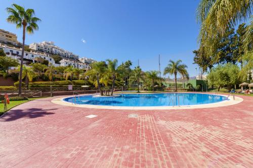 uma piscina num parque com palmeiras em CT 209 - Navigolf Penthouse - La Cala de Mijas em La Cala de Mijas