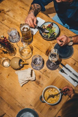 a group of people sitting at a wooden table eating food at Hotel Sportalm - Adults Only Boutique Hotel in Bad Kleinkirchheim