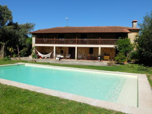 a house with a swimming pool in front of a house at Casas da Azenha do Rio in Barreiros