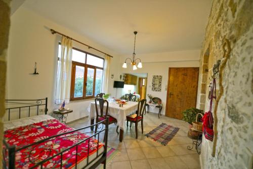 een woonkamer met een tafel en een slaapkamer bij Picturesque Traditional Stone House in Plátanos