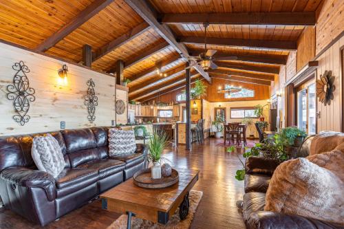 a living room with a leather couch and a table at Hilltop Hideaway in Bigfork
