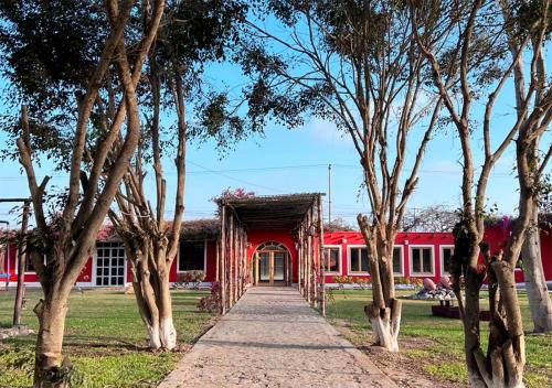 a pathway leading to a red building with a train at La Estancia Chincha Hotel in Chincha Alta