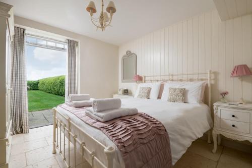 a bedroom with a large white bed and a window at The Hay Barn in York