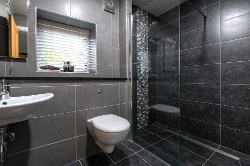 La salle de bains est pourvue de toilettes, d'un lavabo et d'une douche. dans l'établissement The Hay Barn, à York