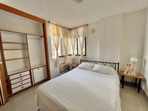 1 dormitorio con 1 cama blanca y 2 ventanas en Perla del Caribe, en Santa Marta