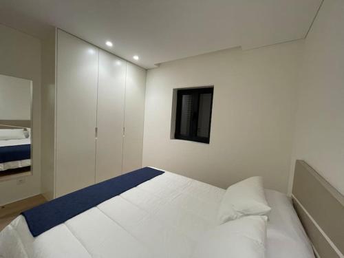 a white bedroom with a large white bed in it at Casa Fermar in Esposende