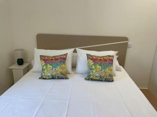 a white bed with two pillows at Casa Fermar in Esposende