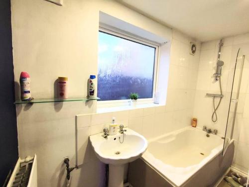 a bathroom with a sink and a bath tub and a window at Citylife Apartment in Old Walker