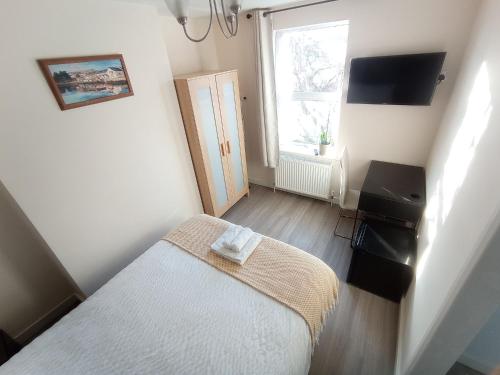 a small bedroom with a bed and a window at Mill View Apartment - Self contained one bed apartment in Oxford