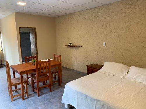 1 dormitorio con 1 cama, mesa y sillas en Departamento LOFT Centrico en San Rafael