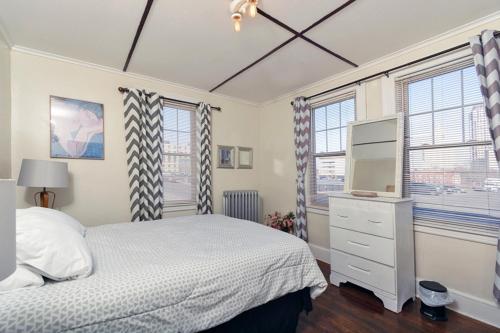 sypialnia z łóżkiem, telewizorem i oknami w obiekcie The Wadsworth Suite A2 w mieście Hartford