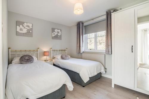 a bedroom with two beds and a window at Sunny Cottage in Brecon