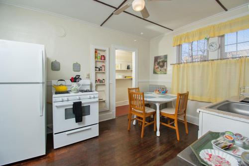 a kitchen with a white refrigerator and a table with chairs at The Wadsworth Suite A2 in Hartford