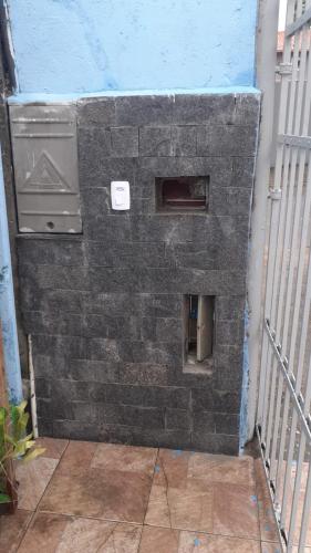 a brick wall next to a building with a heater at CASA PRAIA GRANDE i146 in Praia Grande