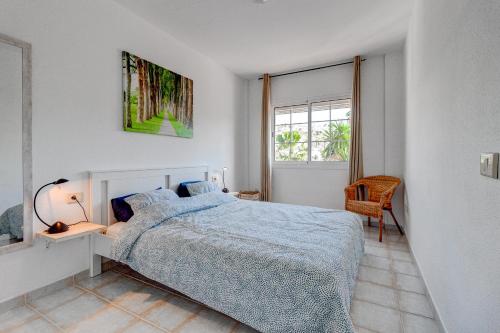 a white bedroom with a bed and a window at La Finca de Chayofa in Chayofa