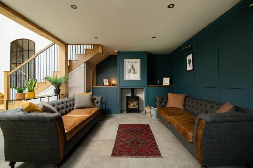 a living room with two couches and a fireplace at The Grand Barn in York