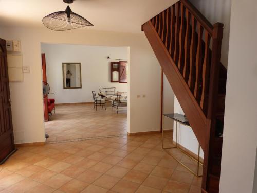 een woonkamer met een trap en een eetkamer bij Villa Magnifique piscine & jardin in Baie-Mahault