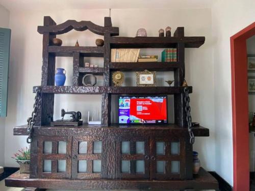 a wooden shelf with a tv on top of it at Casa no Centro Histórico de Catas Altas in Catas Altas