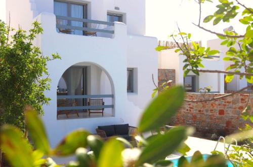 a white building with a balcony and some plants at The Nine Graces - Kastraki Villas with Private Swimming Pool in Kastraki Naxou