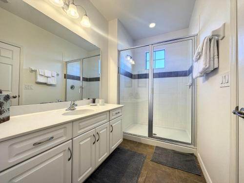 a white bathroom with a shower and a sink at 5 Bed South Facing Pool close to Disney villa in Davenport
