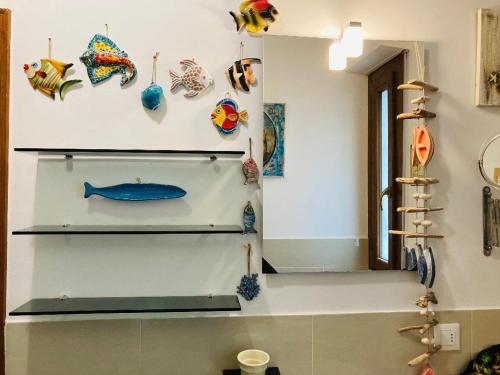 une chambre avec des étagères sur le mur et des ornements de poisson dans l'établissement Melon's House, à Torre del Lago Puccini