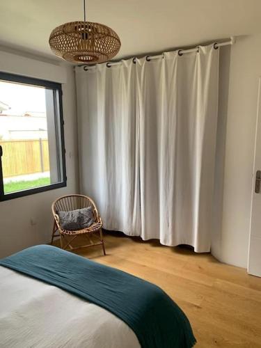 une chambre avec un lit et une fenêtre avec des rideaux dans l'établissement Maison 6 pers proche lac Biscarrosse- Parentis, à Parentis-en-Born