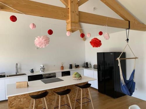 kuchnia z czarną lodówką i blatem ze stołkami w obiekcie Maison 6 pers proche lac Biscarrosse- Parentis w mieście Parentis-en-Born