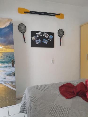 1 dormitorio con 1 cama con 2 raquetas de tenis en la pared en Casa Dos Praieiros, en Jaguaruna