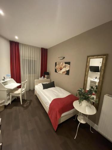 a bedroom with a bed and a desk and a mirror at Arthotel ANA Residence Bremen in Bremen