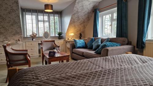 a bedroom with a bed and a couch at Country Retreat at Judd's Folly in Faversham