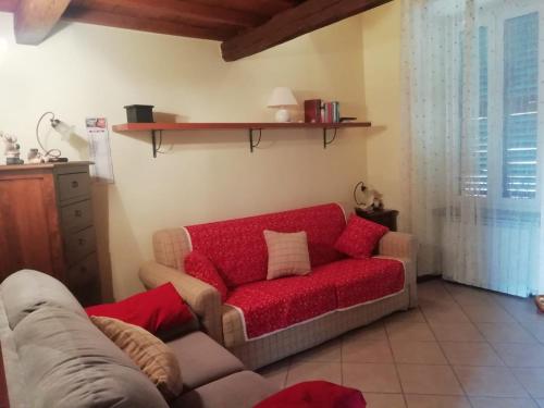 ein Wohnzimmer mit einem Sofa und einem roten Sofa in der Unterkunft La Girandola in Soriano nel Cimino