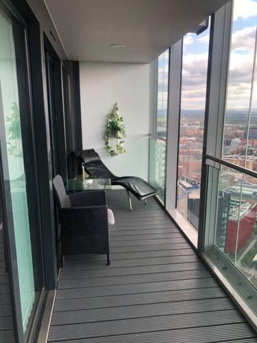- Balcón con mesa y sillas en un edificio en Luxury apartment stunning views, en Mánchester