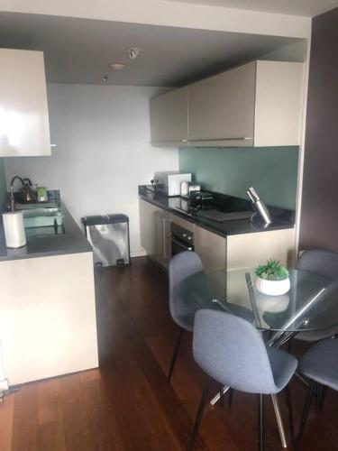 a kitchen with a table and chairs and a counter at Luxury apartment stunning views in Manchester