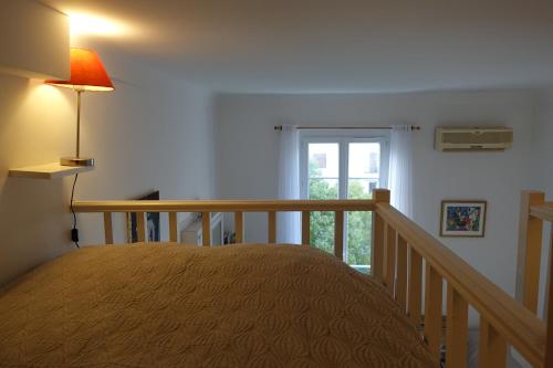 a bedroom with a bed and a staircase with a window at Rue de France mer à 200m in Nice