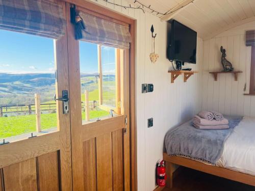 a bedroom with a bed and a window and a television at Ivy's Way in Rhayader