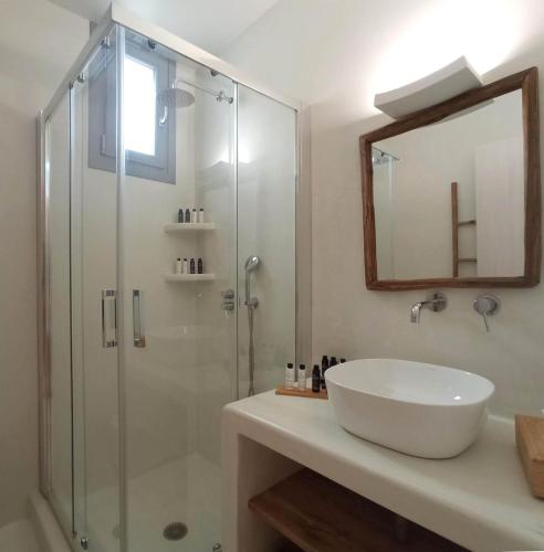 a bathroom with a sink and a shower with a mirror at The Nine Graces - Kastraki Villas with Private Swimming Pool in Kastraki Naxou